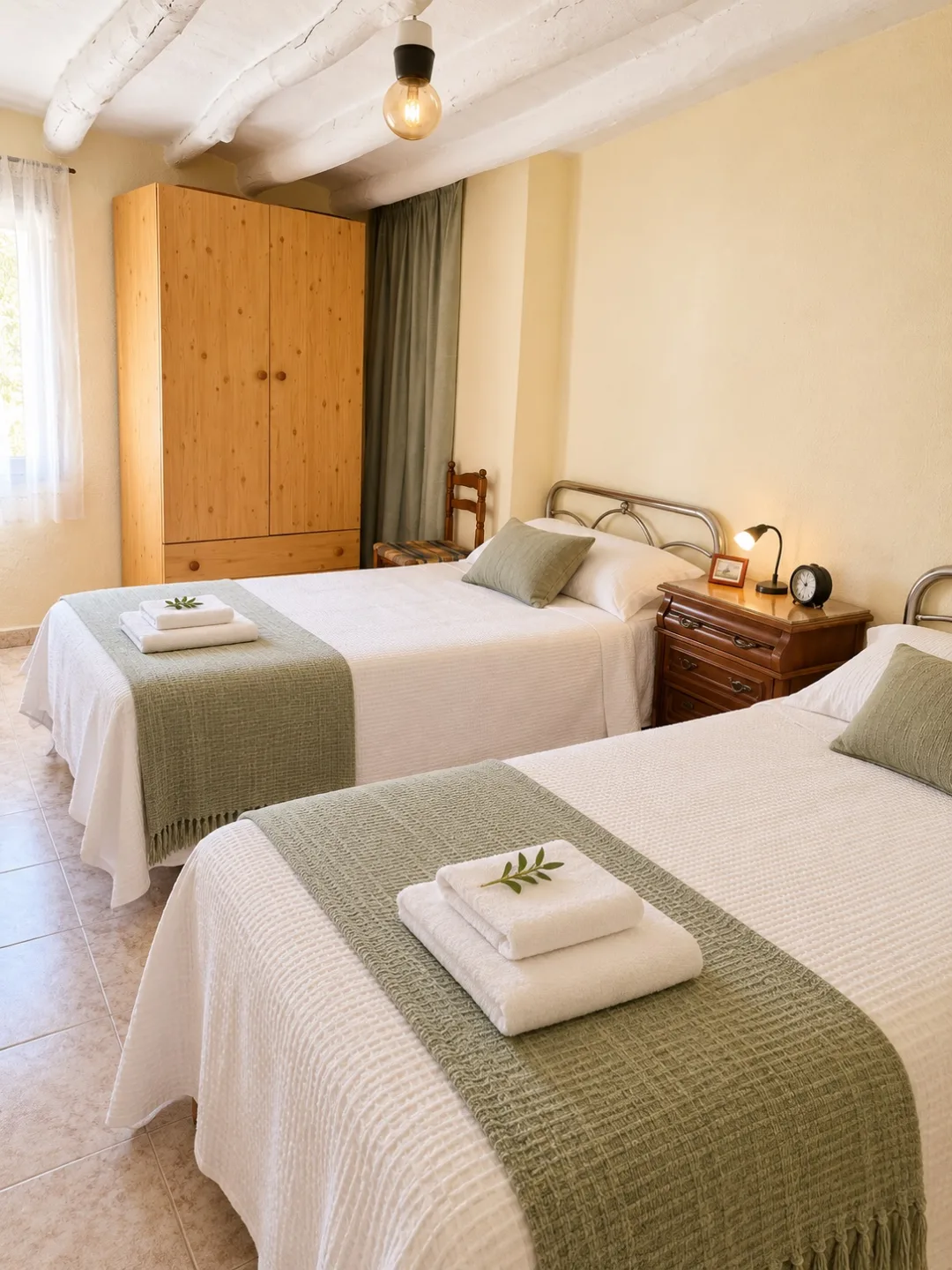 Dormitorio de Casa Plenas con dos camas individuales y toallas